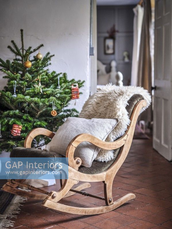 Rustic rocking armchair next to Christmas tree