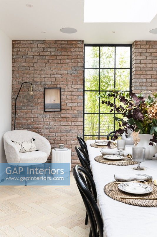 Contemporary dining room with brick wall