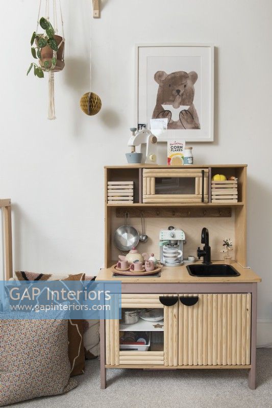 Wooden play kitchen unit in childrens room