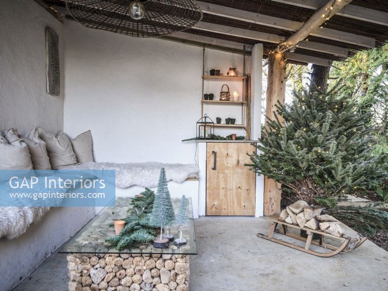 Outdoor space featuring Christmas decor and stacked logs under the coffee table