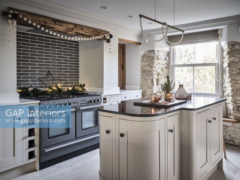 Modern kitchen featuring island unit, exposed brickwork and Christmas decor