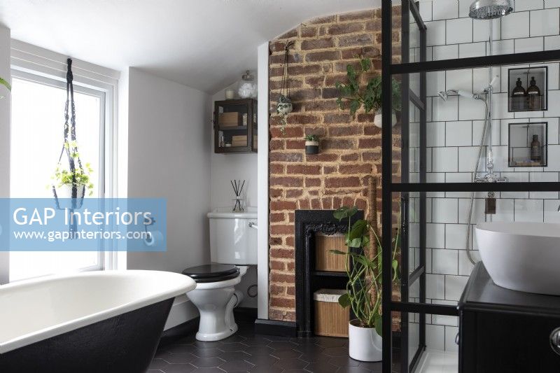 Family bathroom with roll top bath and crittall style shower, exposed brick and chrome accessories