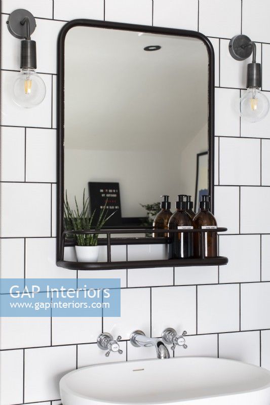 Detail of sink, mirror shelf and industrial wall lights