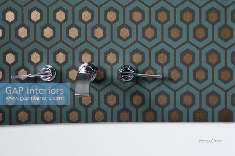 Details of feature wall wallpaper and bath taps.
