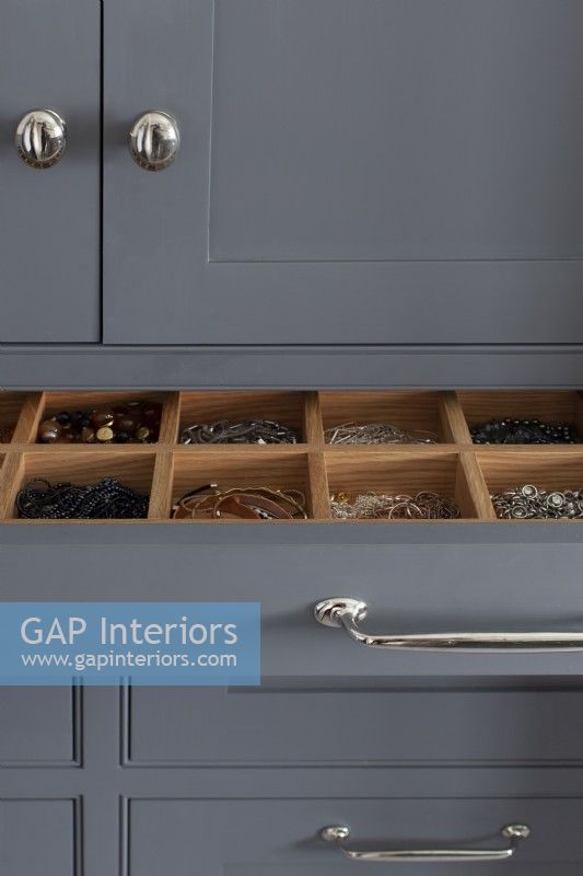 Close up of jewellery drawer in grey bathroom