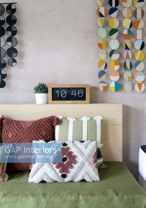 Detail of textured cushions and colourful wall hangings 