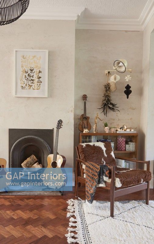 View of a fireplace in a living room with eclectic vintage furniture and accessories. 
