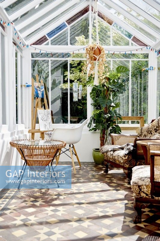 Victorian conservatory or artist room  with a tiled floor and vintage furniture . 
