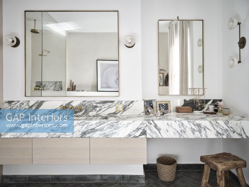 Modern bathroom featuring mirrors and marble surfaces