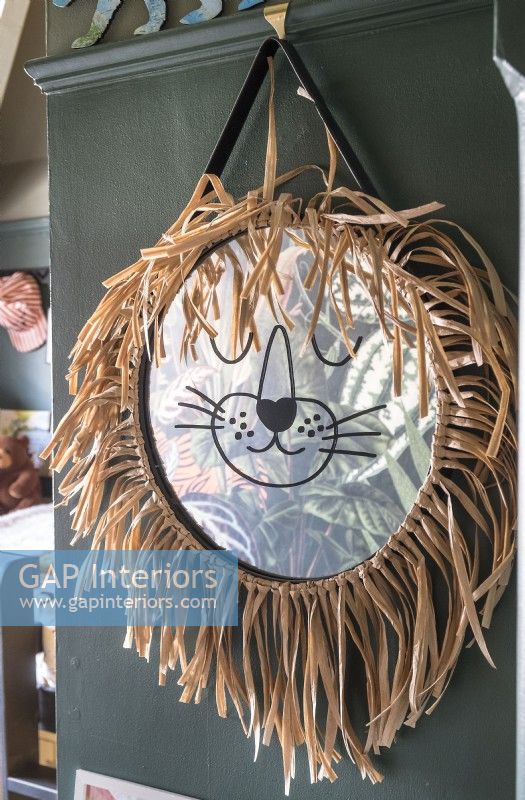 Detail of lion wall hanging mirror and mane in childrens bedroom