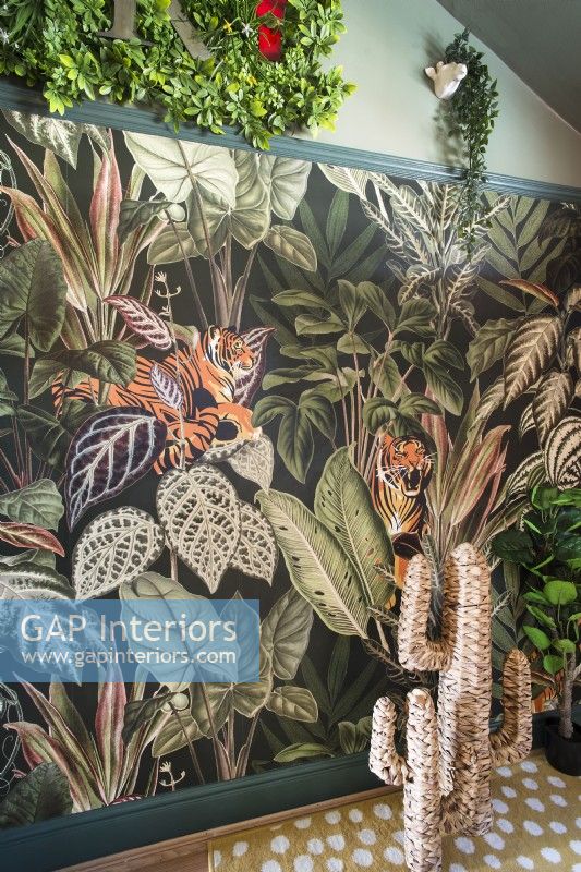 Colourful jungle themed wallpaper feature wall with straw cactus