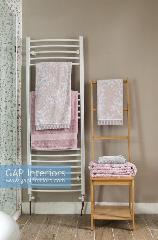 Detail of towel radiator and wooden storage chair 