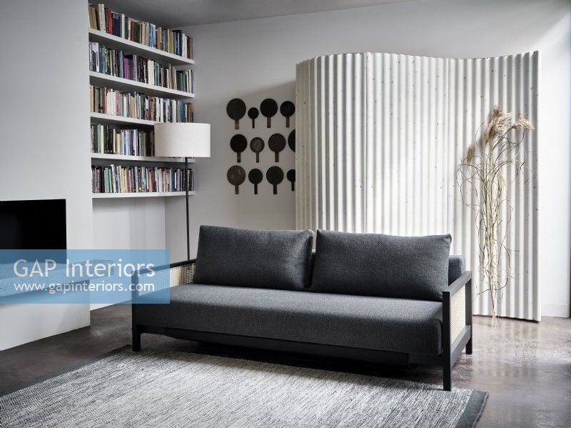 Grey sofa infront of curved feature screen