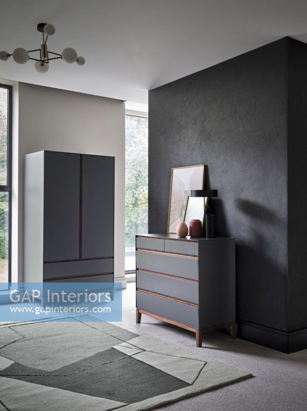 Grey chest of drawers against grey feature wall in modern room