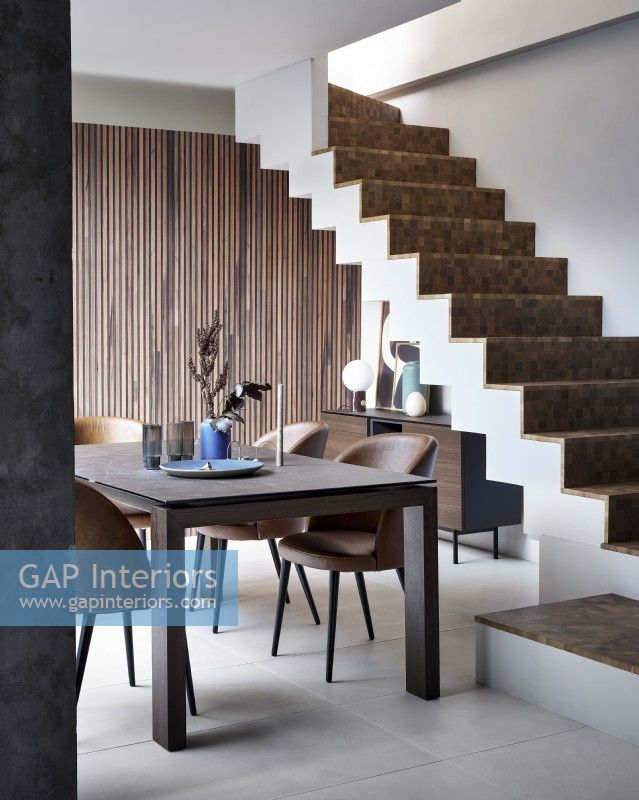 Dining table at bottom of contemporary staircase