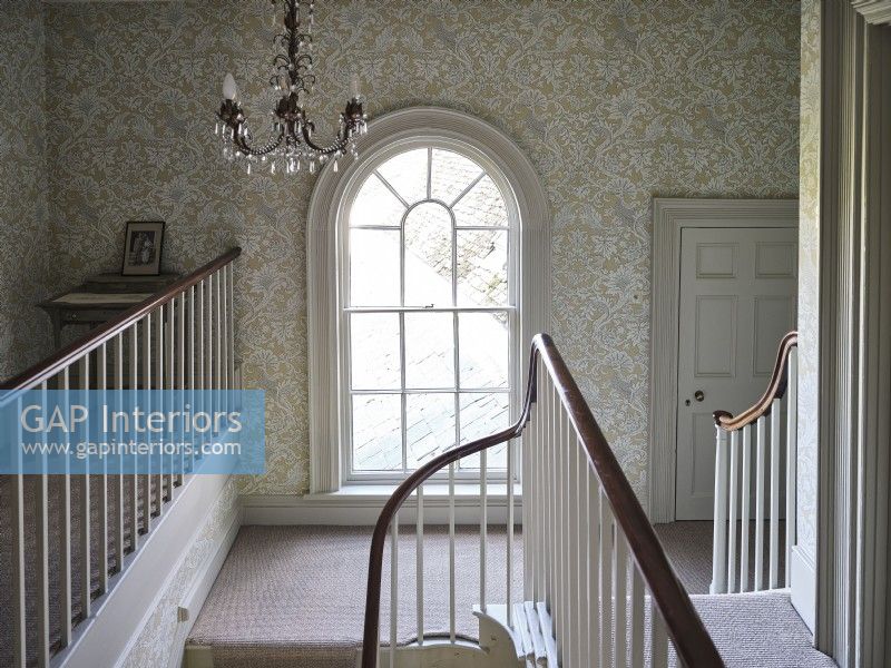 Traditional hallway featuring a round top window