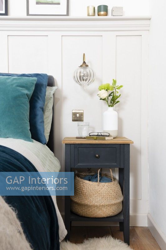 Bedside table with basket in a country style bedroom