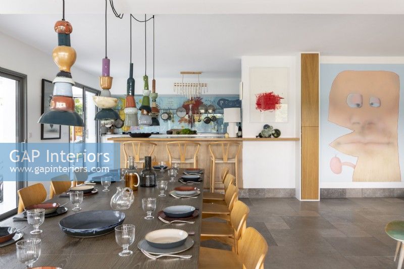 Modern kitchen-diner with quirky artwork and ceramic lights