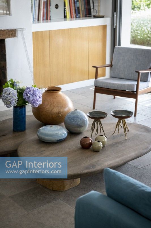 Ceramic objects on low wooden coffee table in modern living room