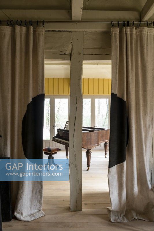 View through curtains to grand piano in country house