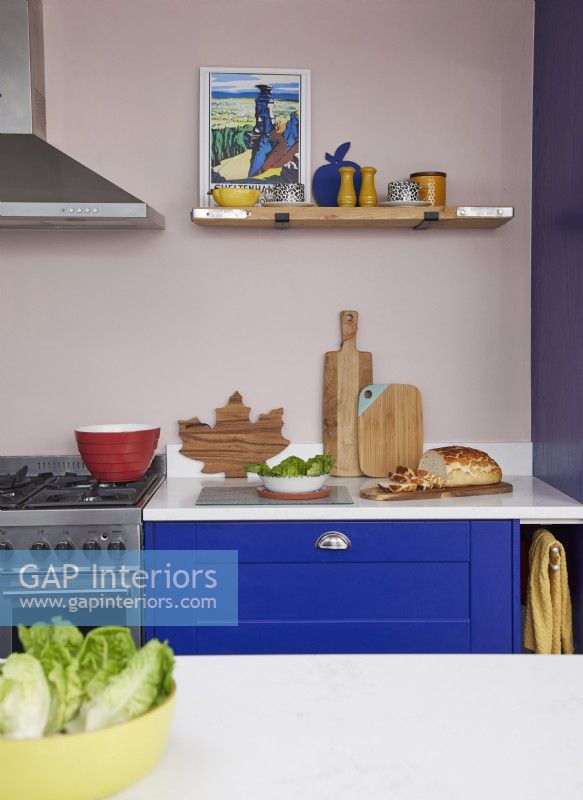 Colourful kitchen detail with cobalt blue cabinets and open shelving.