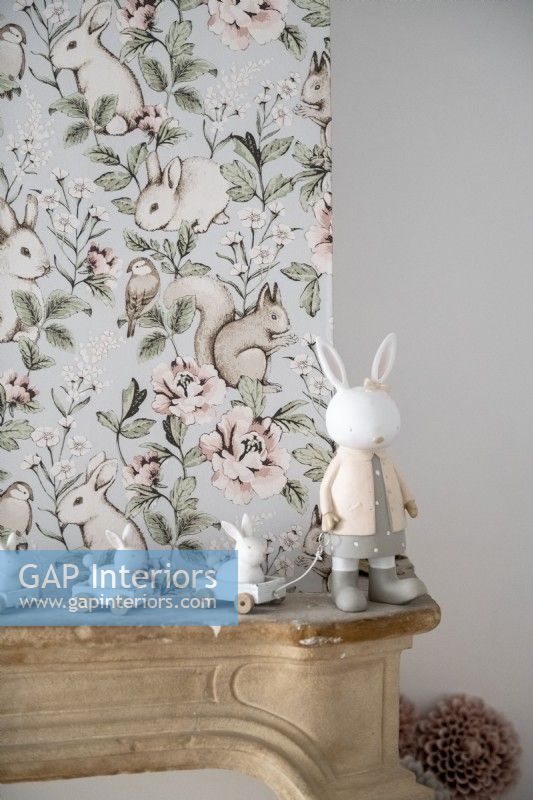 Rabbit ornament next to wallpapered wall in childs bedroom - detail