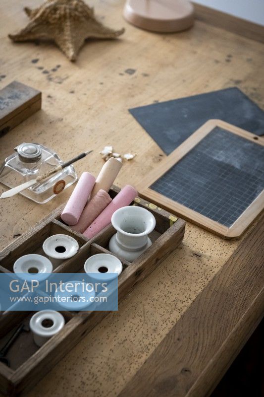 Chalk and small chalkboards on wooden desk