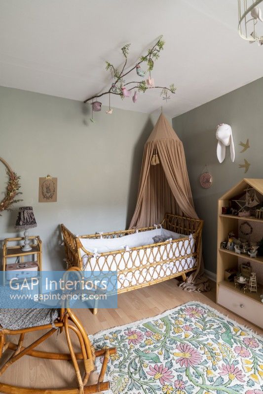 Baby nursery with canopy over wicker crib