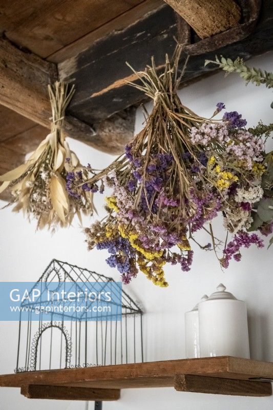 Detail of dried flowers hanging from exposed wooden beams