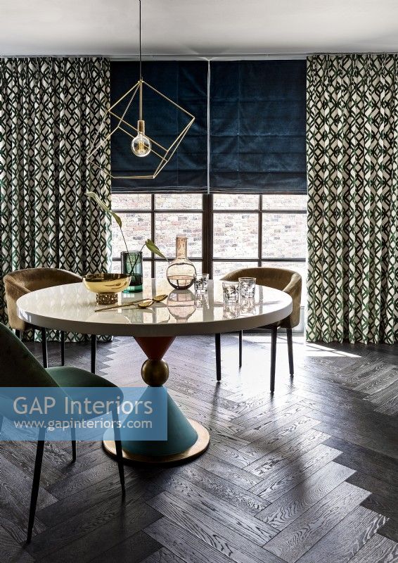 Dining table with patterned curtains and blue blind