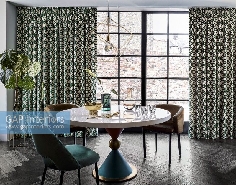 Dining table with objects and patterned curtains