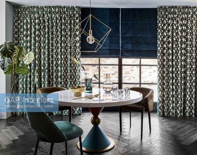 Dining table with patterned curtains and blind