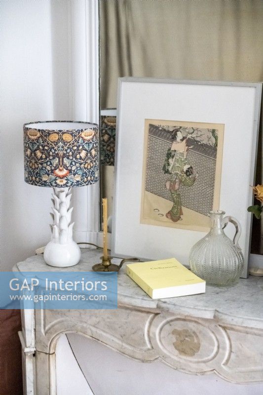Artwork and decorative lamp on mantelpiece 