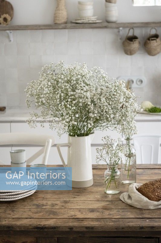White flowers on wooden table in country kitchen