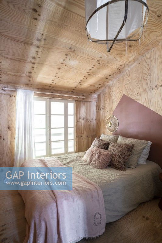 Bedroom with wooden walls and ceiling
