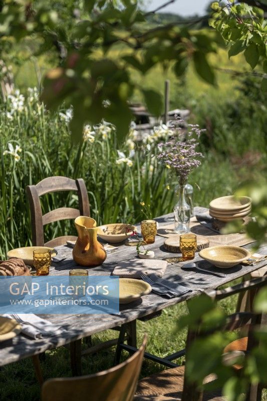 Detail of outdoor dining table in country garden set for lunch