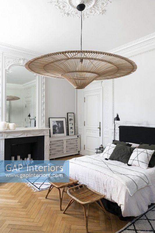Large wicker lampshade and period details in classic style bedroom 