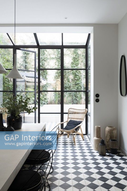 Contemporary monochrome dining room with crittall doors to garden