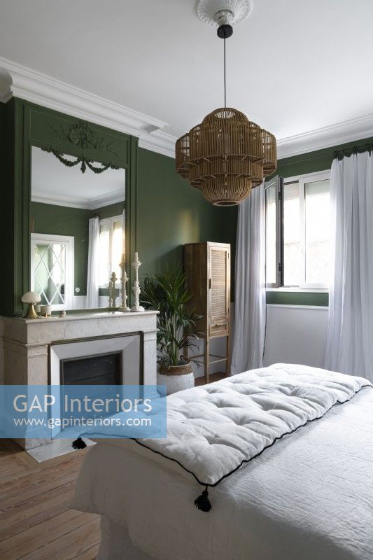Fireplace in green and white painted bedroom with period details 