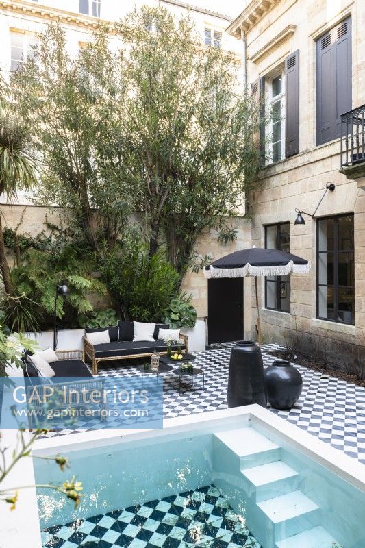 Swimming pool on terrace with checked paving tiles