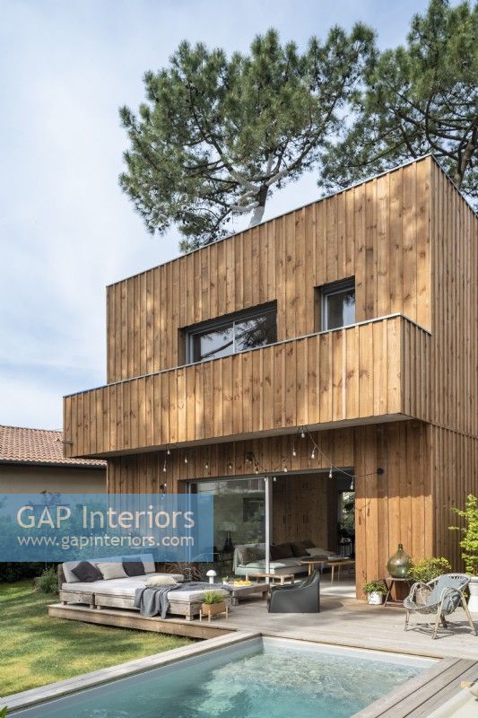Exterior of modern home with wooden cladding and swimming pool