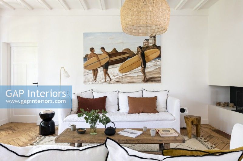 Large painting of surfers above sofa in modern country living room
