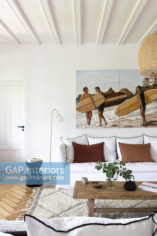 Painting of surfers on wall of white modern country living room