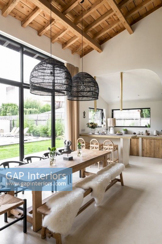 Modern kitchen-diner with sheepskins draped over wooden benches
