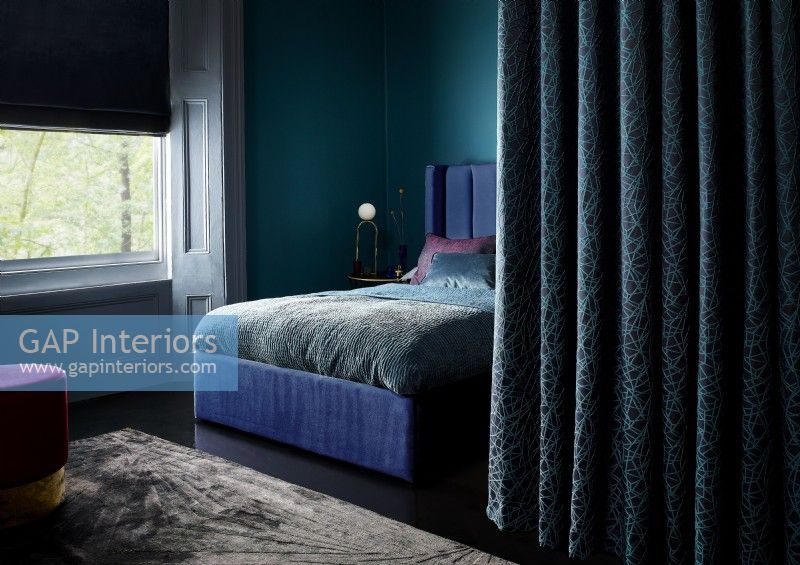 Rich blue bedroom with curtain divider