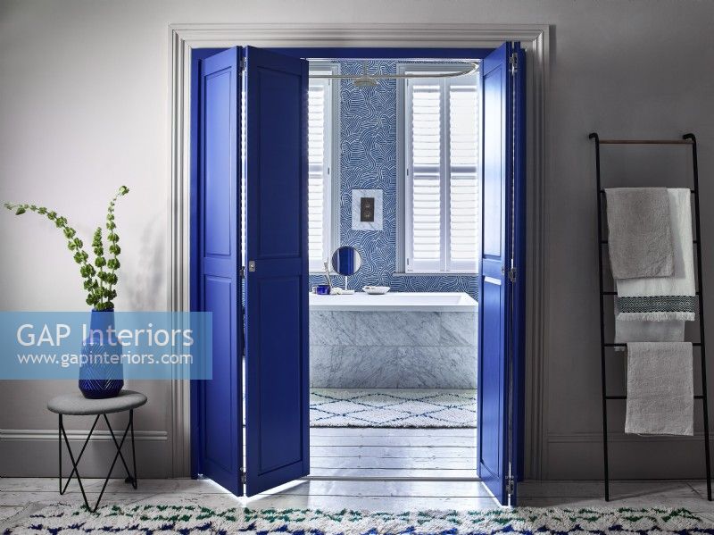 En suite bathroom with blue shutter dividing doors