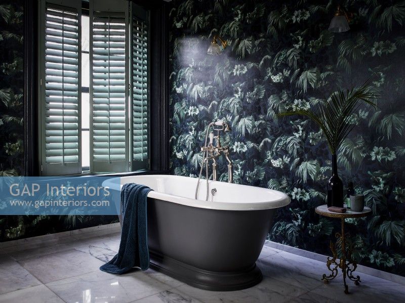 Luxurious bathroom with patterned wallpaper and green shutters cracked open