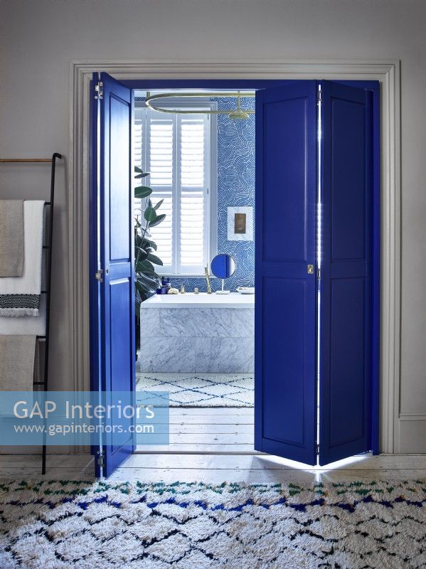 En suite bathroom with blue shutters in dividing doorway