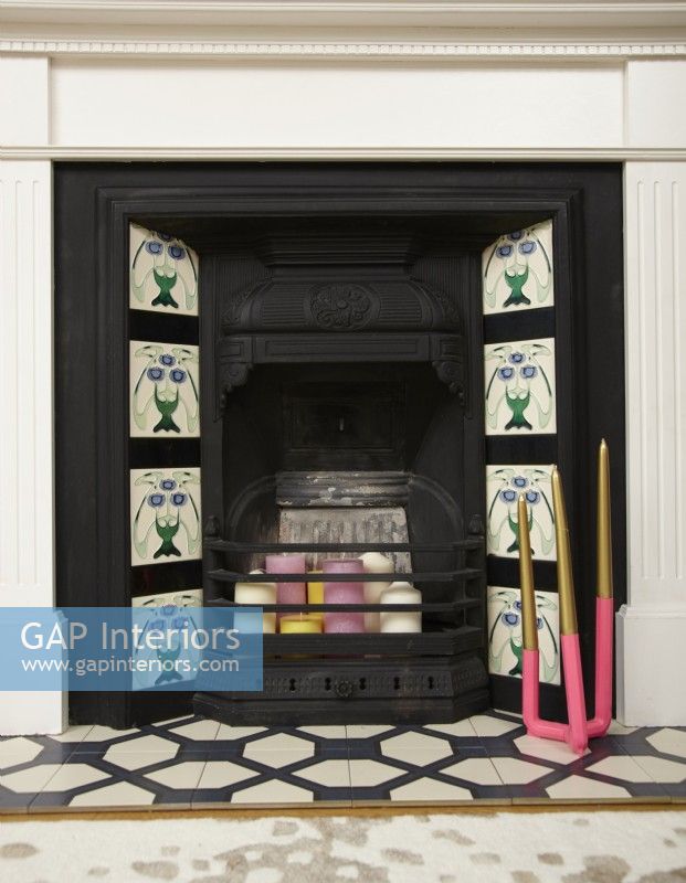 Living room detail showing fireplace with tiles and candles.
