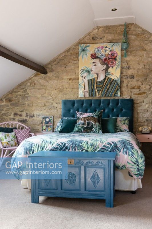 Attic bedroom with York stone wall and blue painted antique blanket box